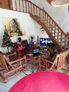 um grupo de pessoas sentadas numa sala de estar a ver televisão em Villa Maria em Somone