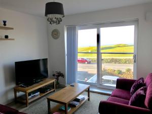 sala de estar con sofá y ventana grande en Alishan Cornwall Holidays en Newquay