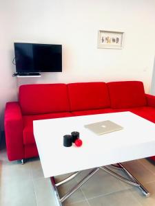 a living room with a red couch and a table at Cœur de Nice Gare du Sud Terrasse Parking in Nice