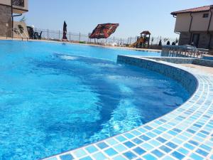a large swimming pool with blue water at Menada Imperial Heights Villas in Sunny Beach
