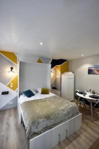 a bedroom with a large bed and a table at Opal'évasion - RDC- Cocon pour 2 pers - 250m de la mer in Berck-sur-Mer