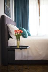 a vase of flowers on a table next to a bed at Studio Apartment Zen City Centre in Split