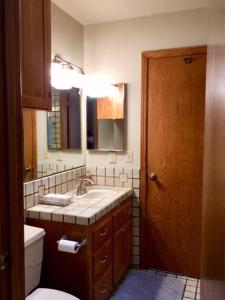 a bathroom with a sink and a toilet and a mirror at Kin House Guest Suite in Oakhurst