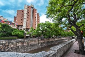 a river in a city with tall buildings at Hotel de la Cañada in Córdoba