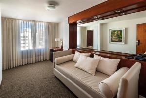 a living room with a couch and a mirror at Hotel de la Cañada in Córdoba