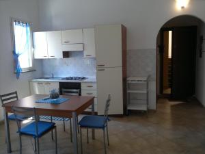 a kitchen with a table and chairs and a refrigerator at Liana monolocale in San Vincenzo