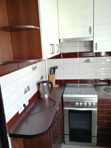 uma cozinha com armários brancos e um forno com placa de fogão em Daily rent Apartments 4 em Ivano-Frankivsʼk