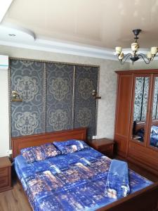 um quarto com uma cama com um edredão azul em Daily rent Apartments 4 em Ivano-Frankivsʼk