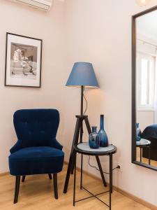 Zimmer mit einem blauen Stuhl und einem Tisch mit einer Lampe in der Unterkunft New City Center Design Apartment in Poreč