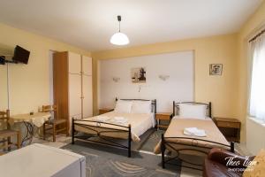 a room with two beds and a table at Orama Rooms in Ioannina