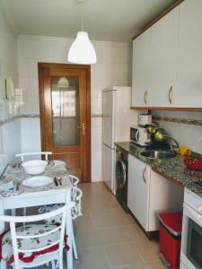 cocina con armarios blancos y encimera en Apartamento en OVIEDO,WIFI, en Oviedo