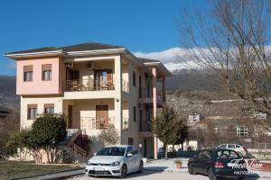 una casa con dos coches estacionados frente a ella en Orama Rooms, en Ioannina