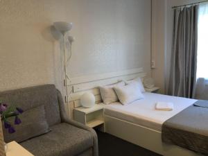 モスクワにあるミニホテル リンゼーのベッドと椅子付きのホテルルーム