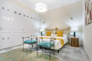 a bedroom with a bed and two chairs at Casa Palacio Madre de Dios in Seville