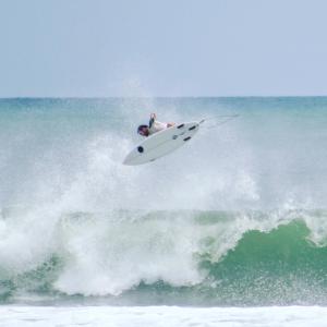 una persona montando una ola en una tabla de surf en el océano en San Marcos 124 Gran Pacifica Resort, en San Diego