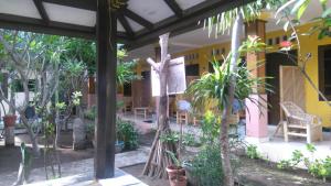 Koi Gili Guest House في غيلي تراوانغان: رجل يقف على شجرة في حديقة +17 صورة