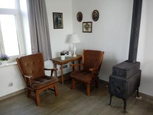 a room with a stove and two chairs and a table at Hauwaertshoeve in Beernem