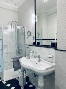 a white bathroom with a sink and a shower at Villa Bagatelle - Luxury apartment in Nice