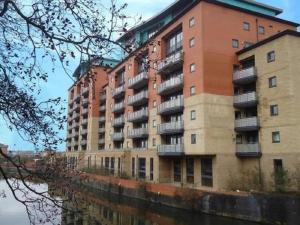 un edificio alto junto a un cuerpo de agua en Empire Serviced Apartments, en Leicester