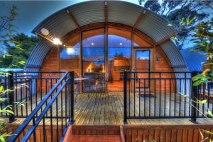 a round house with a wooden deck and a glass door at 43 Degrees Bruny Island in Adventure Bay