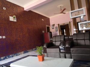 a waiting room with leather chairs and a table at Chairosana Mansion in Bhubaneshwar