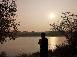 a man standing next to a body of water at Chairosana Mansion in Bhubaneshwar
