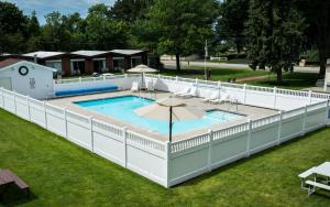 an overhead view of a pool with a white fence around it at Nader's Motel & Suites in Ludington
