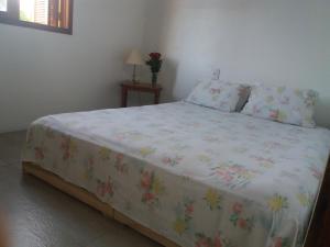 Un dormitorio con una cama con una colcha floral. en H&C Pousada Ap, en São Gabriel