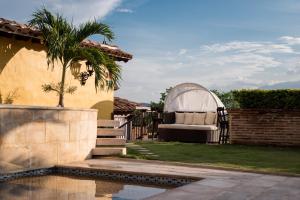 un patio trasero con una palmera y un sofá junto a una casa en Nueva Granada Hotel Colonial -Centro Histórico-, en Santa Fe de Antioquia