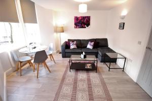 a living room with a couch and a table at Willow Serviced Apartments - 22 in Cardiff