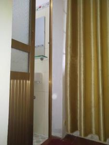 a bathroom with a shower with a yellow curtain at Nhà hàng Nhà nghỉ Dù Lượn Khau Phạ in Mù Cang Chải
