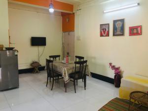 a dining room with a table and chairs and a tv at Furnished apt w. 2 bed rooms in New Alipore in Kolkata