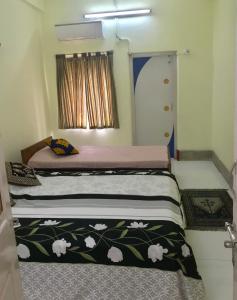 a bedroom with a bed with a black and white blanket at Furnished apt w. 2 bed rooms in New Alipore in Kolkata