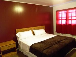 a bedroom with a bed and a red wall at Super 54 Inn in Minneola