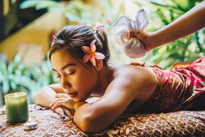 a young woman laying on a table with a flower in her hair at Hotel Puri Melaka in Melaka