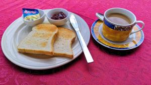 a plate with toast and a cup of coffee and a cup of jam at Walkerz Inn in Panglao Island +32 photos