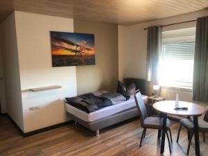 a room with a bed and a table and a table and chairs at Pension Flying Ranch in Dermsdorf
