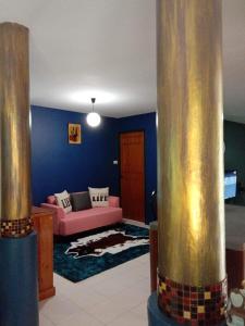 un soggiorno con divano rosa e palo d'oro di Blue Villa @Pinery Park Beach Rayong 2bdr Villa a Rayong