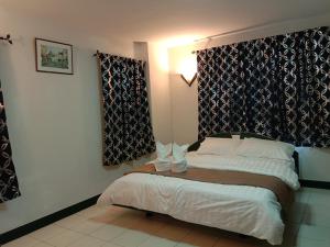 Blue Villa @Pinery Park Beach Rayong 2bdr Villa في رايونغ: غرفة نوم بسرير وستائر في غرفة