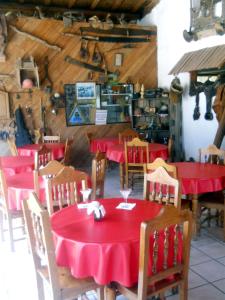 a restaurant with tables and chairs with red table cloth at Hotel Paraiso del Oso in Cerocahuí