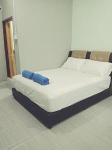 uma cama com uma almofada azul em cima em IZ Budget em Kampung Kuala Besut