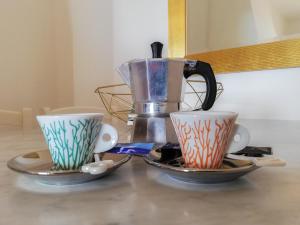 dos tazas en una mesa con una cafetera en La Coccinella, en San Venanzo