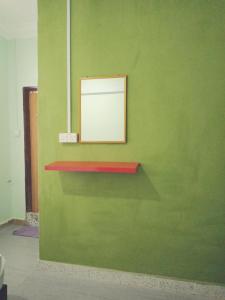 Una pared verde con una foto encima. en IZ Budget, en Kampung Kuala Besut