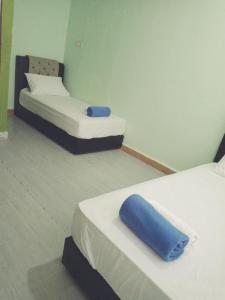 a room with two beds and a blue pillow at IZ Budget in Kuala Besut