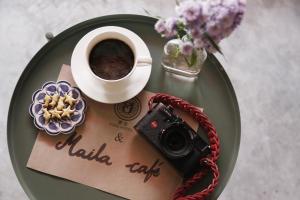 une tasse de café et une caméra sur un plateau dans l'établissement Hong hostel, à Bangkok