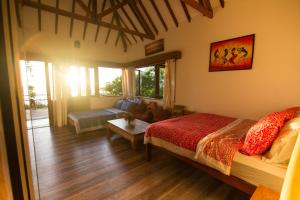 a bedroom with a bed and a living room at Boa Hill Surf House in Nembrala +70 photos