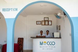 a man and woman standing in front of a counter at Mocco Beach Villa in Kendwa