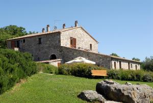 a large stone building with a bench in front of it at Podere Pietreta in Radicofani