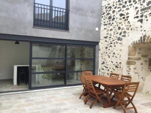 a wooden table and chairs on a patio at Maison de bourg avec cour privée in Tallende