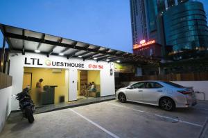 a white car parked in front of a store at LTL Guesthouse in Johor Bahru
